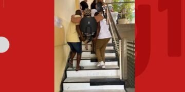 Mulher é carregada em cadeira para votar